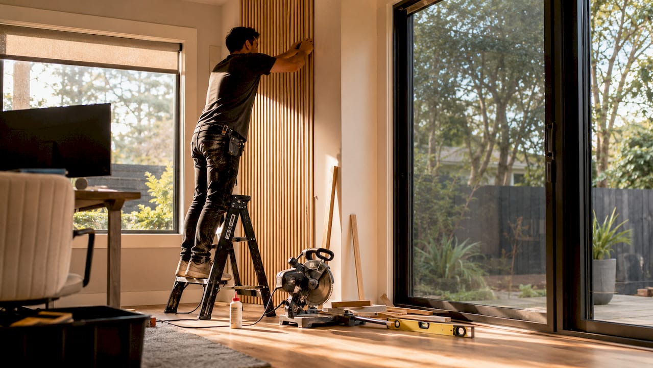 Contractor installing bamboo slat wall indoors
