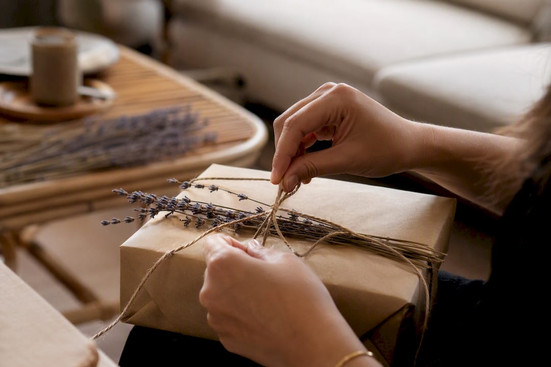 Hands wrapping gift with natural materials