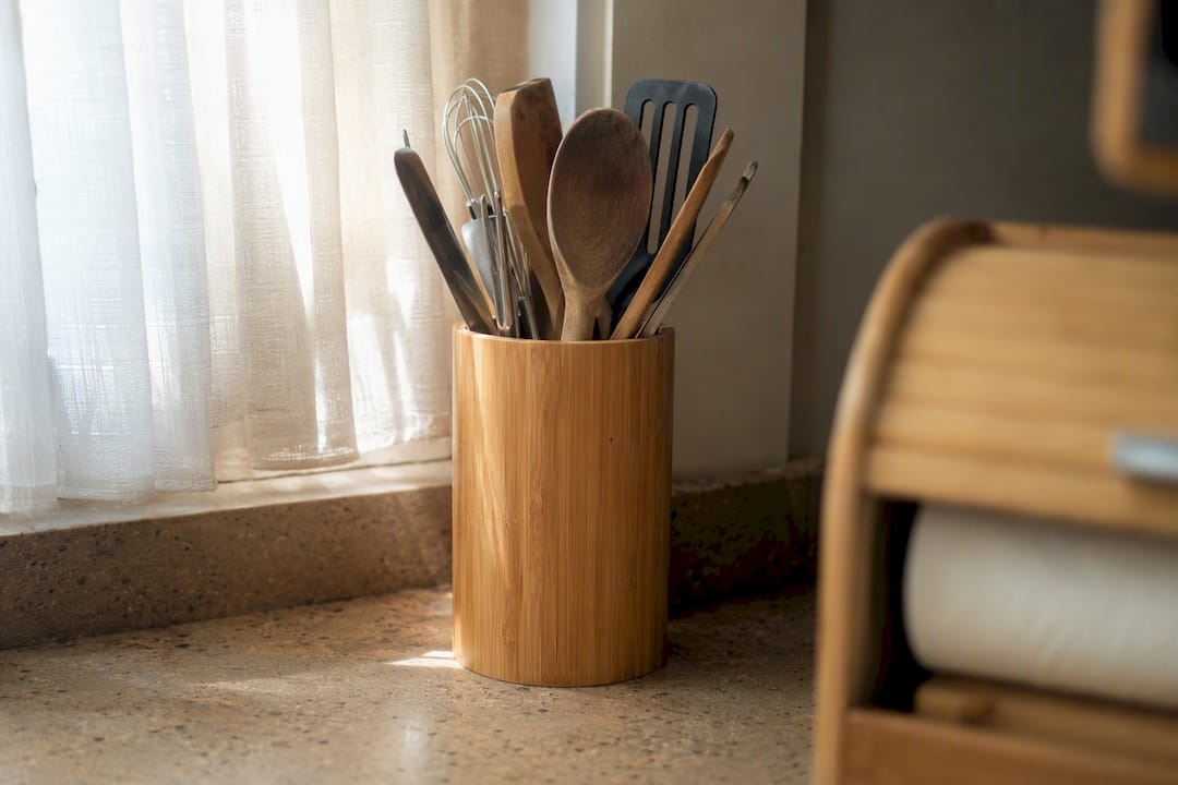 Bamboo utensil holder with cutlery in small kitchen